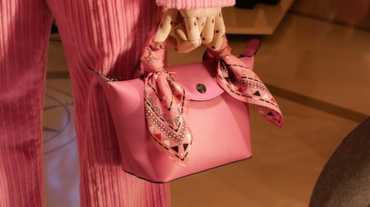 Sac Longchamp en cuir rose avec foulard autour de la poignée