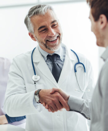 Un médecin serre la main d'un patient avec le sourire