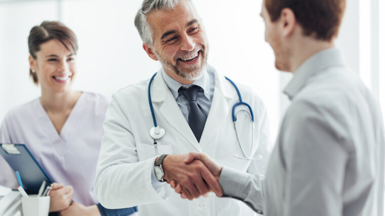 Un médecin serre la main d'un patient avec le sourire